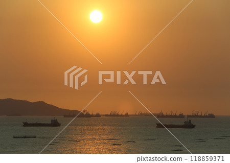 Sea is filled with cargo ships and fishing boats at dusk. Sea is filled with cargo ships and fishing boats at dusk. 118859371
