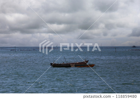 A fishing boat floats in the middle of the sea.. A fishing boat floats in the middle of the sea.. 118859480