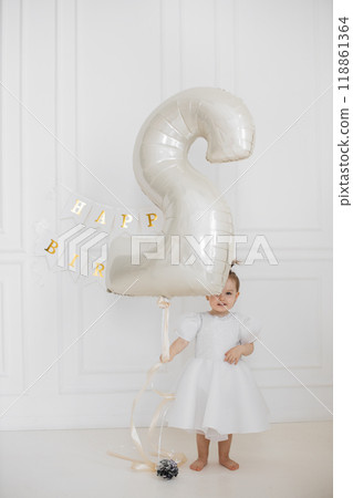 Joyful toddler celebrating second birthday with large balloon Joyful toddler celebrating second birthday with large balloon 118861364