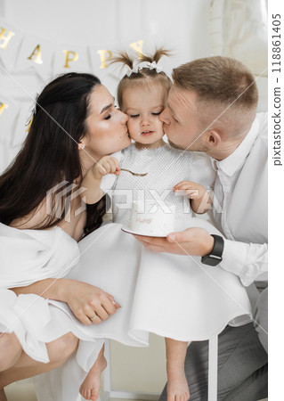 Parents celebrate daughters second birthday with cake and love Parents celebrate daughters second birthday with cake and love 118861405