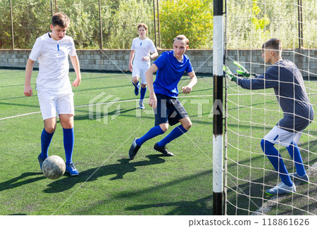 Junior football teams having golmouth scramble 118861626