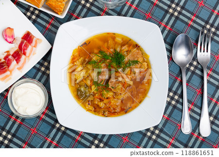 Shchi cooked from sauerkraut with pork meat served with sour cream 118861651