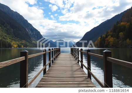 A calm lake surrounded by mountains and a wooden pier 118861654