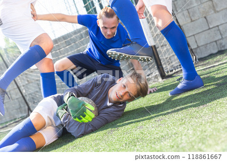 Goalkipper lying on lawn with ball in hands 118861667