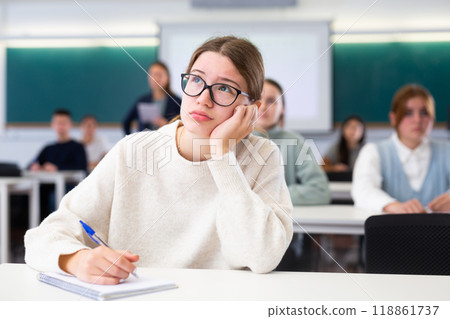 Young girl student diligently studies at school 118861737