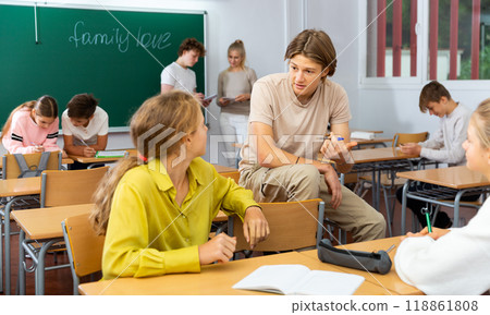 Teenage school pupils talking during break in classroom 118861808