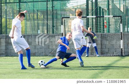 Teens playing soccer football match. Competition between two youth soccer teams Teens playing soccer football match. Competition between two youth soccer teams 118861965