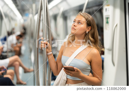 Young girl standing in wagon holding phone in hand 118862000