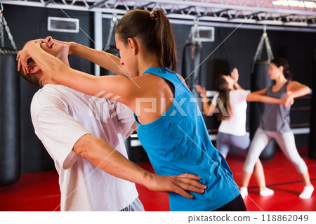 Woman practising eye gouging self-defensive move in gym 118862049
