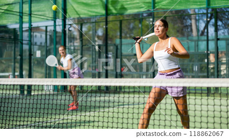 Two women tennis players playing padel Two women tennis players playing padel 118862067
