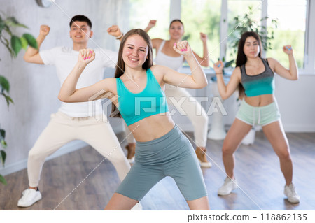 Teenage girl practicing hip-hop movements during group dance class 118862135