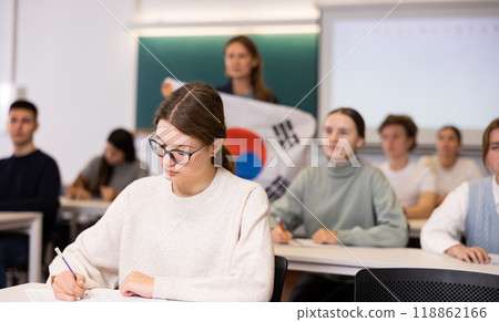 High school teacher holds the flag of South Korea in her hands and talks about this country in geography lesson High school teacher holds the flag of South Korea in her hands and talks about this country in geography lesson 118862166