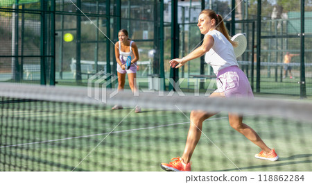 Two women tennis players playing padel Two women tennis players playing padel 118862284