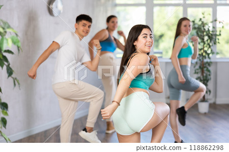Cheerful teen girl training movements of modern group dance Cheerful teen girl training movements of modern group dance 118862298