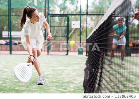 Young emotional women playing paddle tennis outdoors 118862400