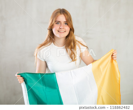 smiling girl in arms raised above head holds canvas of national flag of Ireland smiling girl in arms raised above head holds canvas of national flag of Ireland 118862482