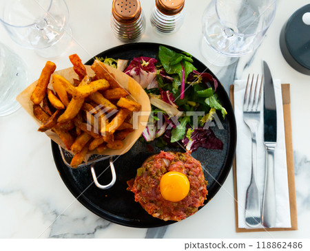 Beef steak tartare with raw egg yolk and salad 118862486
