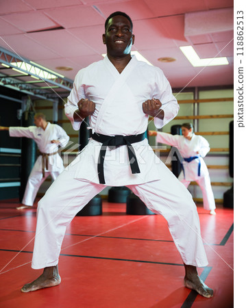 African-american man in kimono doing kata in gym 118862513