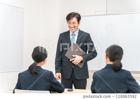 A male instructor/teacher teaching junior and senior high school students in a cram school/school classroom 118863592