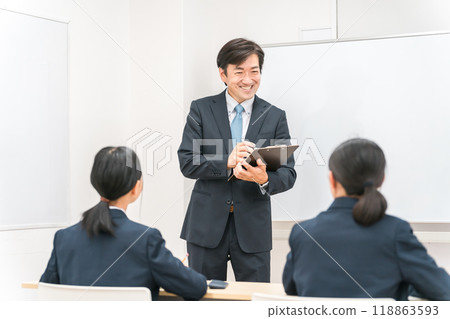 Smiling Asian male cram school instructor, teacher, student listening to teacher Smiling Asian male cram school instructor, teacher, student listening to teacher 118863593