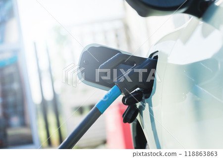Idea about using electric cars. Close up an electric car user is holding a black charger to recharge an electric car. The use of electric cars as the latest alternative energy source in Thailand. 118863863
