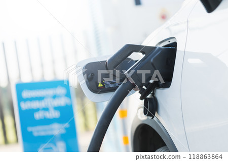 Concepts about using electric cars. Close up an electric car user is holding a black charger to recharge an electric car. The use of electric cars as the latest alternative energy source in Thailand. 118863864