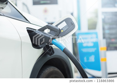 Concepts about using electric cars. Close up an electric car user is holding a black charger to recharge an electric car. The use of electric cars as the latest alternative energy source in Thailand. 118863866