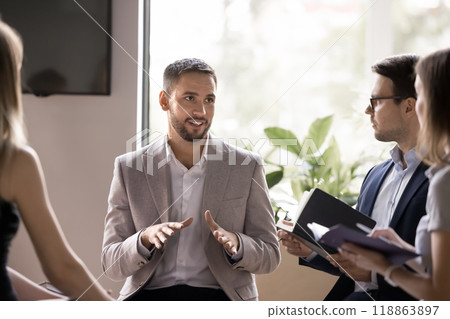Positive successful handsome business leader man talking to team Positive successful handsome business leader man talking to team 118863897