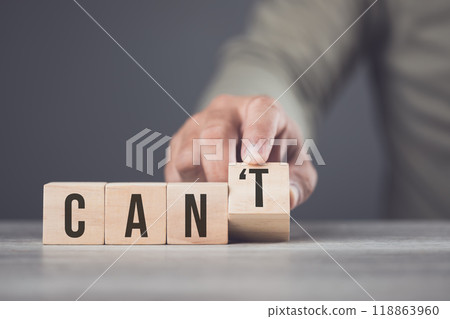 A hand separates the letter "T" from the word "can't," transforming it into "can." The image symbolizes overcoming obstacles, shifting from doubt to empowerment, and embracing a positive mindset. A hand separates the letter "T" from the word "can't," transforming it into "can." The image symbolizes overcoming obstacles, shifting from doubt to empowerment, and embracing a positive mindset. 118863960