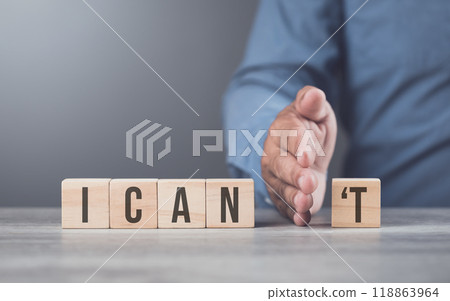 A hand separates the letter "T" from the word "can't," transforming it into "can." The image symbolizes overcoming obstacles, shifting from doubt to empowerment, and embracing a positive mindset. A hand separates the letter "T" from the word "can't," transforming it into "can." The image symbolizes overcoming obstacles, shifting from doubt to empowerment, and embracing a positive mindset. 118863964