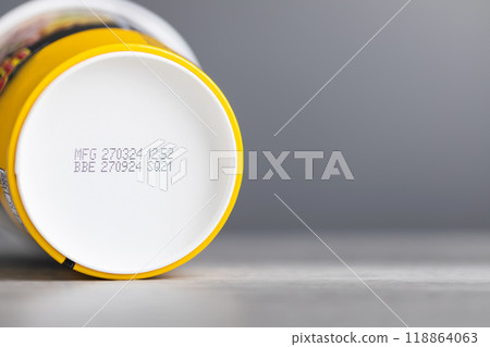 Production and expiration codes printed beneath a clear food container of instant noodles. The image highlights the importance of checking product dates for safety and quality Production and expiration codes printed beneath a clear food container of instant noodles. The image highlights the importance of checking product dates for safety and quality 118864063