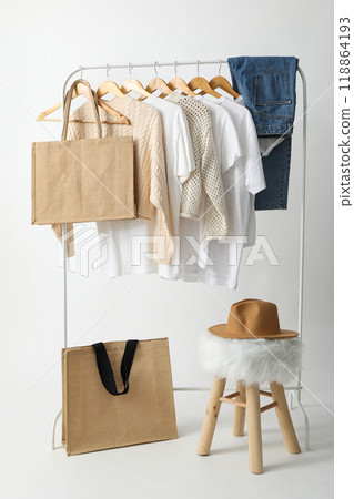 A bag hangs on a hanger with clothes 118864193