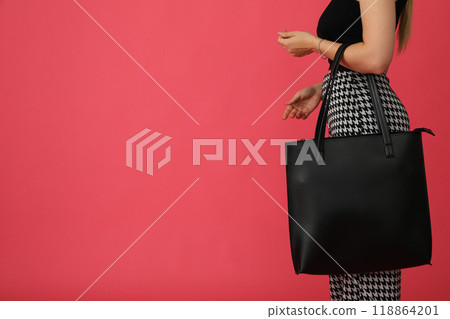 Black bag in female hands on a red background Black bag in female hands on a red background 118864201