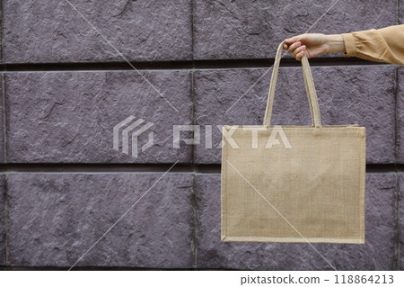 A bag in a woman's hand on a brick background 118864213