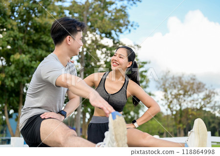 An active, sporty Asian couple in sportswear stretches their legs and warms up before running. 118864998