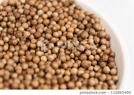 Coriander grains in a plate macro top view. Coriander grains in a plate macro top view. 118865409