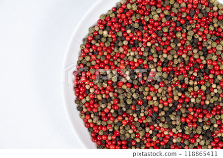 A mixture of different peppercorns on a white background, top view, copy space for text A mixture of different peppercorns on a white background, top view, copy space for text 118865411