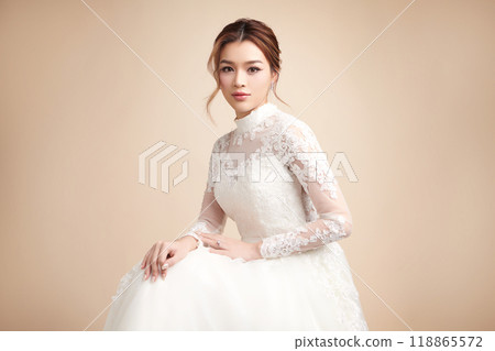 Beautiful young asian woman in wedding dress on beige background, 118865572