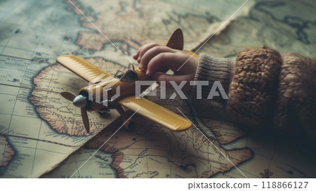 A child's hand holds a model airplane over an old map. 118866127