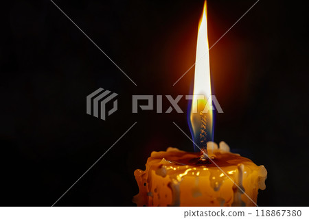 Close-up of a candle burns in the dark. Close-up of a candle burns in the dark. 118867380