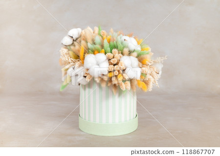 beautiful bouquet of dried flowers in a cardboard basket on a light background. Space for text 118867707