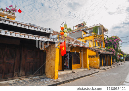 Streets with traditional ancient yellow houses in old town in Hoi An city in Vietnam at summer day Streets with traditional ancient yellow houses in old town in Hoi An city in Vietnam at summer day 118868421