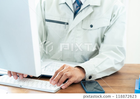 一名穿著工作服的男子正在操作電腦 118872623