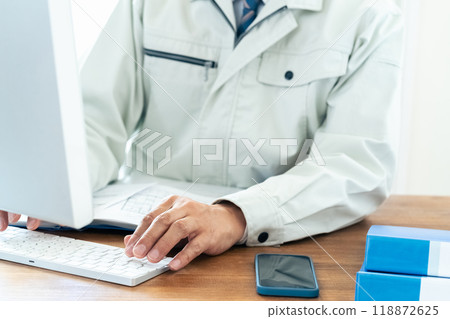 一名穿著工作服的男子正在操作電腦 118872625