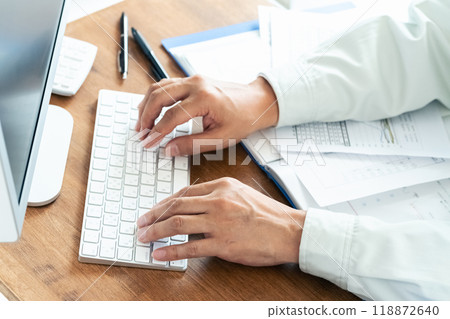 A man in work clothes operating a computer 118872640