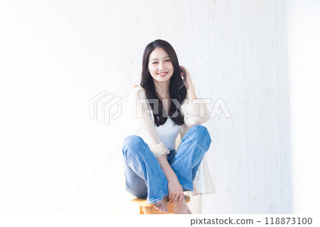 A young woman sitting on a chair A young woman sitting on a chair 118873100