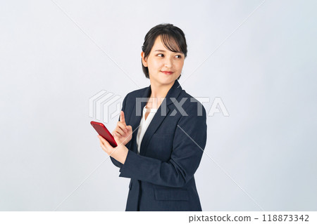 一位穿著西裝的女商人使用智慧型手機 一位穿著西裝的女商人使用智慧型手機 118873342