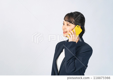A woman in a suit talking on a smartphone A woman in a suit talking on a smartphone 118873366