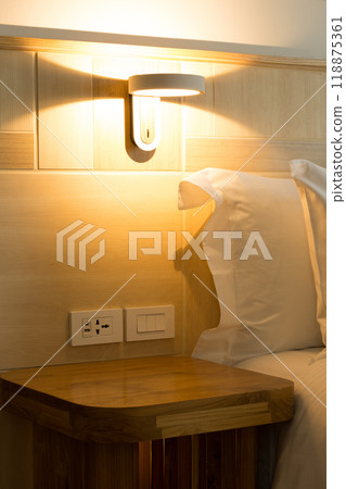 Wall lamp providing bedside lighting with a warm glow. 118875361