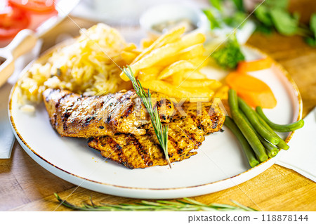 Tender grilled porterhouse or t-bone steak served with crisp golden French fries and fresh green herb salad accompanied by a BBQ or tomato ketchup sauce 118878144